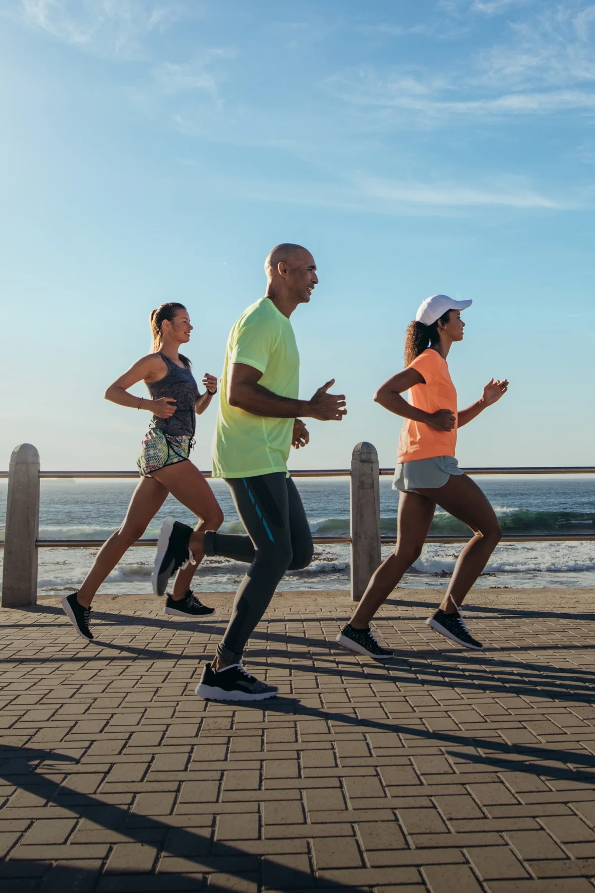 Runners on a boardwalk along the coastline