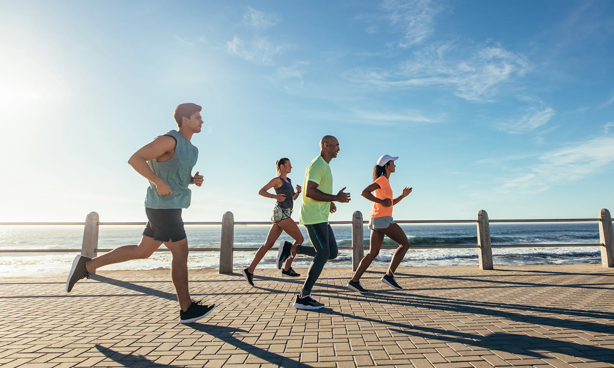 Runners on a boardwalk along the coastline